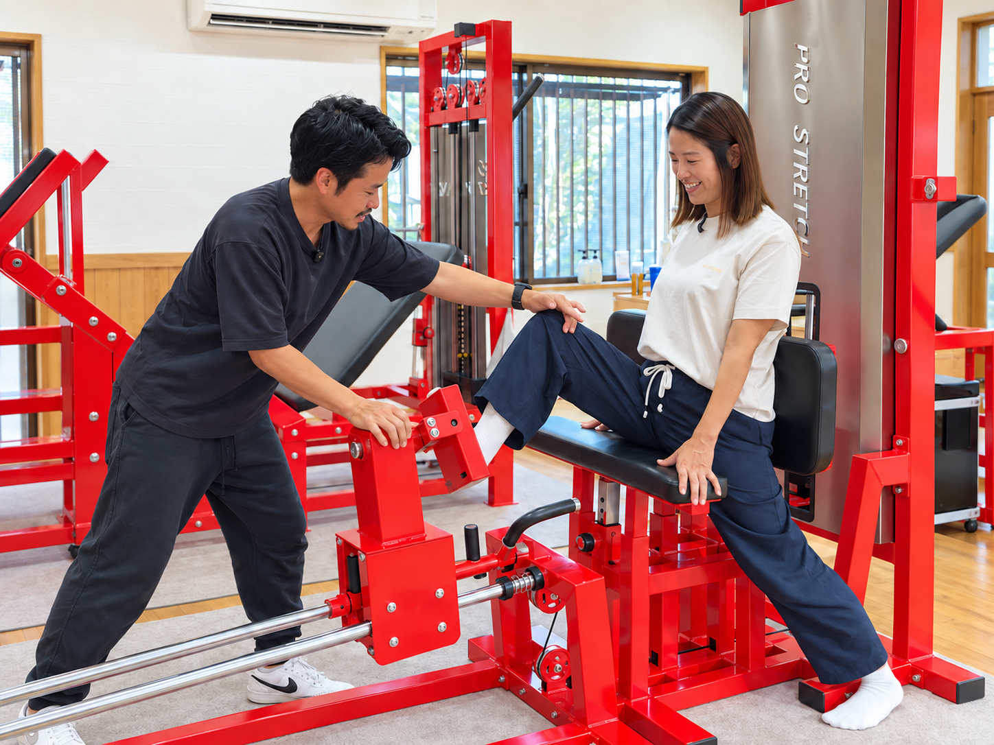スタッフのサポートを受けながらストレッチマシンを体験する様子