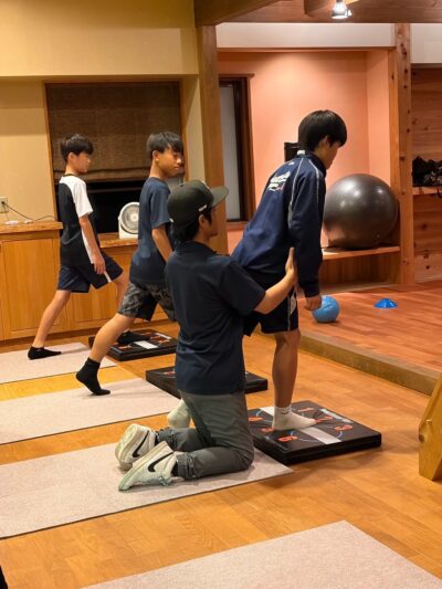 ALINEのグループレッスンで、参加者の姿勢とバランスをトレーナーが確認している様子